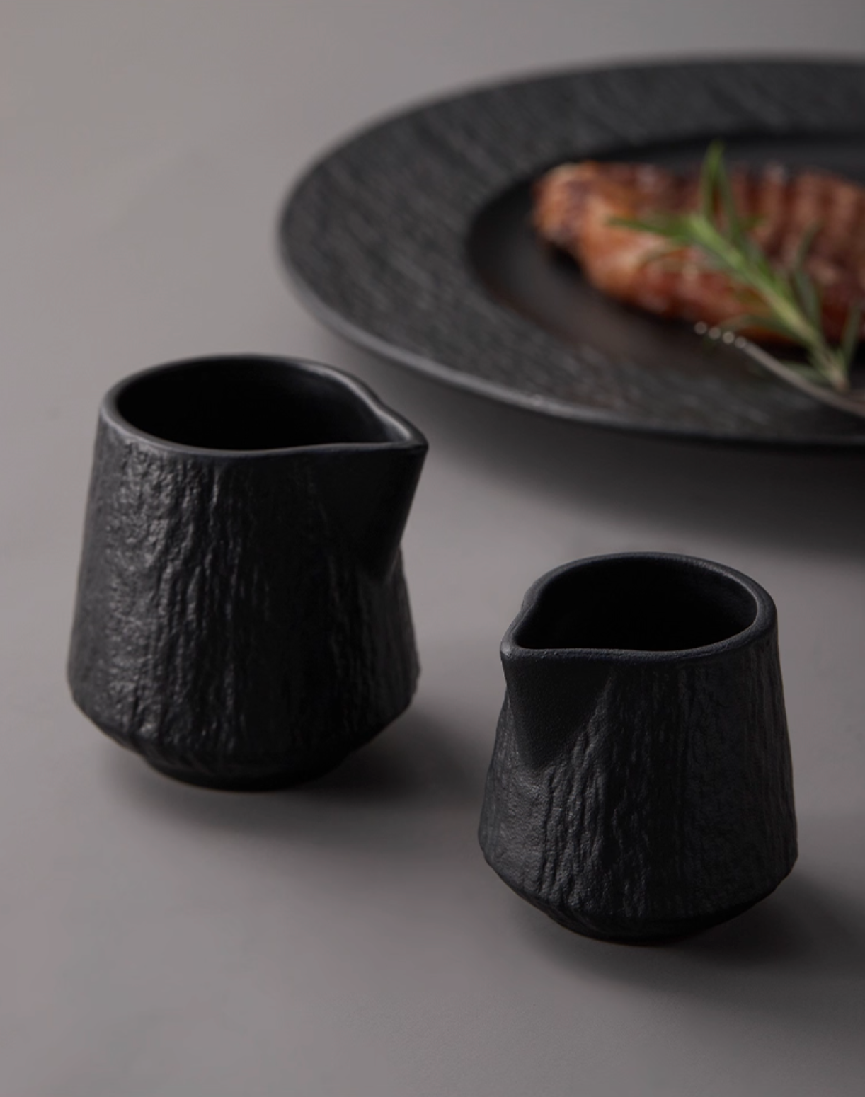 Side view ceramic sauce pourer showing ergonomic handle design