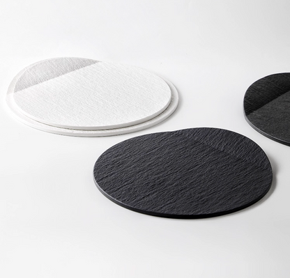 Round black and white flat plates on a light gray background