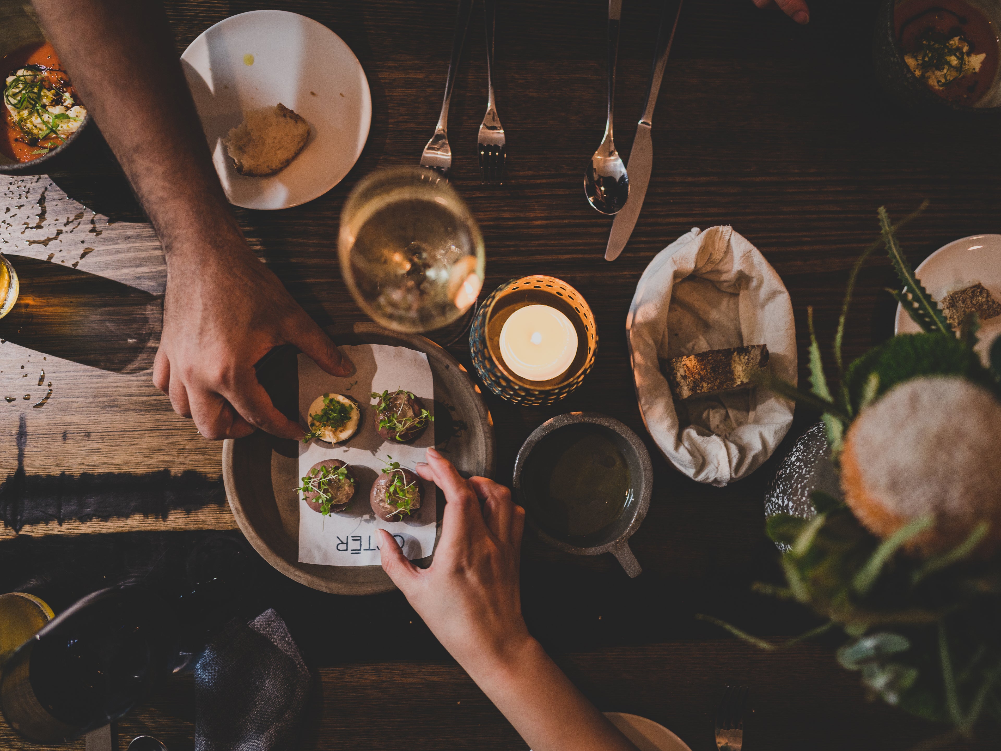 Artisanal ceramic serving plates and glassware on natural wood surface - handcrafted dinnerware collection